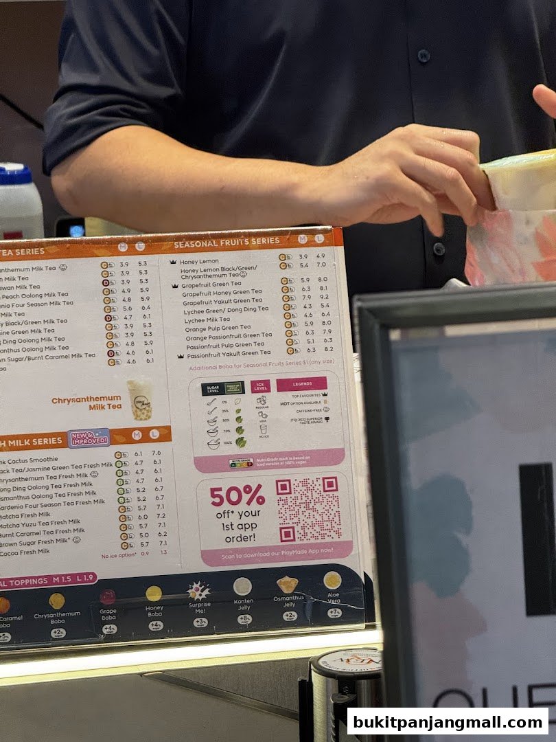 A menu board for PlayMade featuring various milk teas, seasonal fruit teas, and toppings with prices.