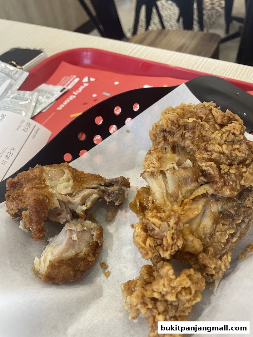 Close-up of crispy fried chicken pieces served in a basket on a red tray.