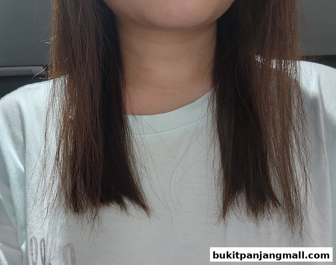 Close-up of a woman's brown hair and light blue t-shirt.