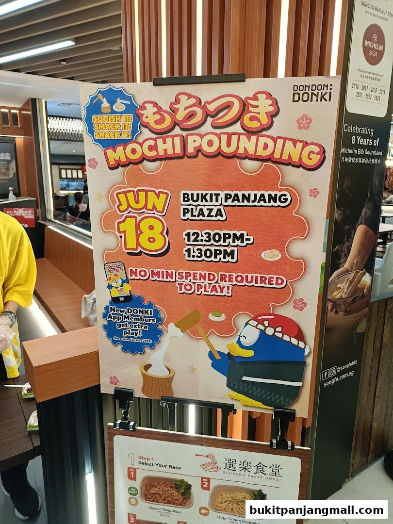 A promotional sign for a Mochi Pounding event at Don Don Donki, featuring a cartoon penguin.