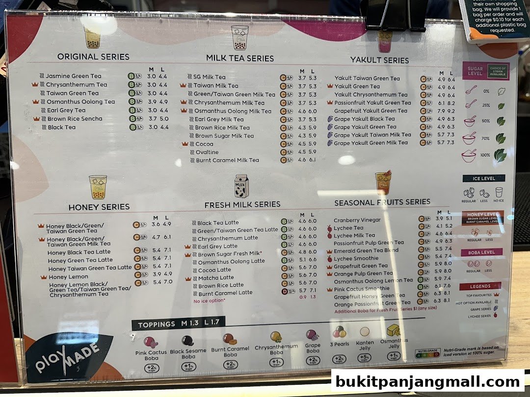 A menu board displaying various milk tea, Yakult, honey, fresh milk, and seasonal fruit tea options with prices.