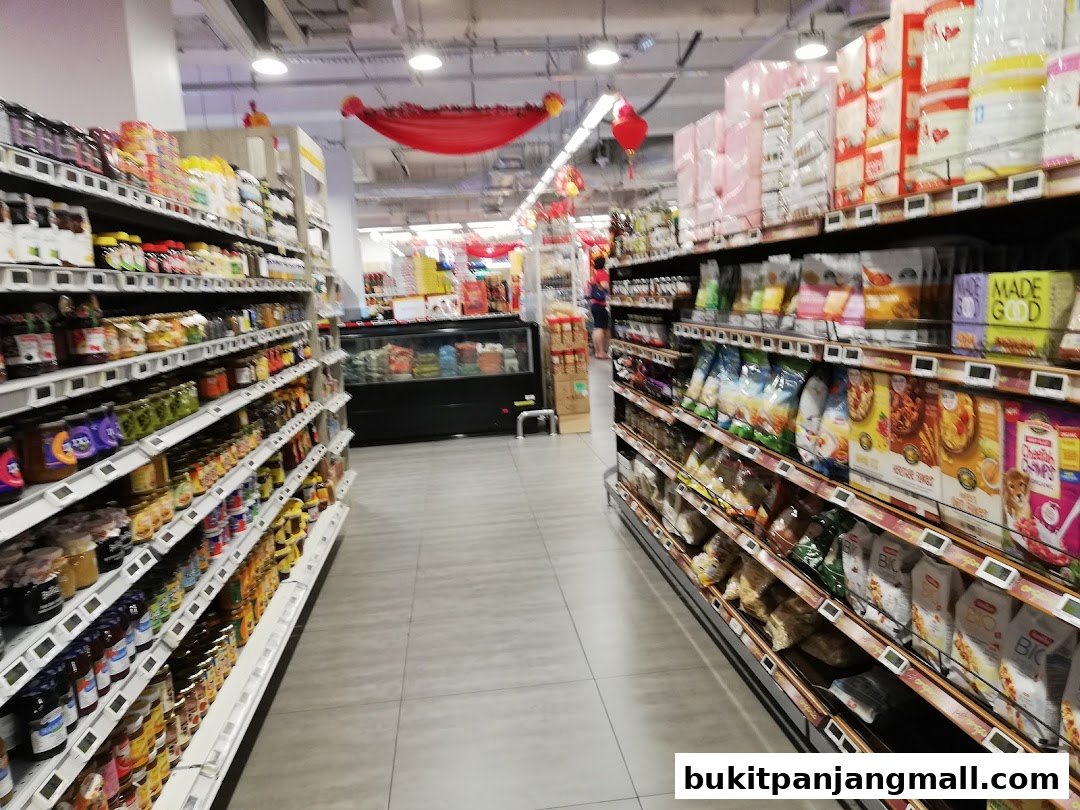 Aisle view of a FairPrice Finest supermarket with shelves stocked with groceries and snacks.