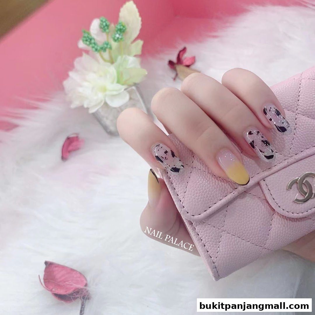 A hand with stylish, patterned nails rests on a pink quilted accessory.