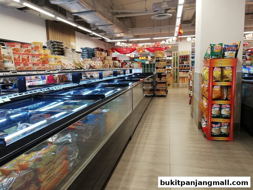A wide aisle in a FairPrice Finest supermarket with frozen food displays and snack shelves.