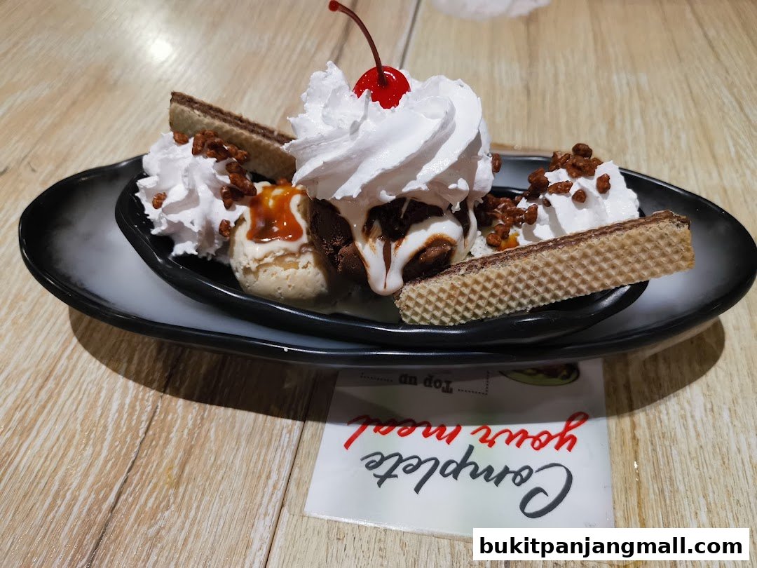 A delicious ice cream sundae with whipped cream, wafers, and a cherry on top.
