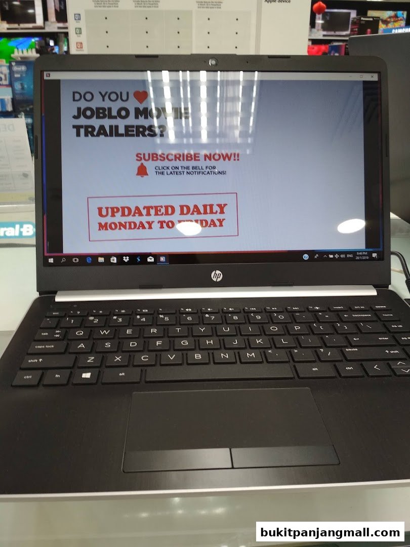 A laptop screen displays a subscription prompt for movie trailers, updated daily.