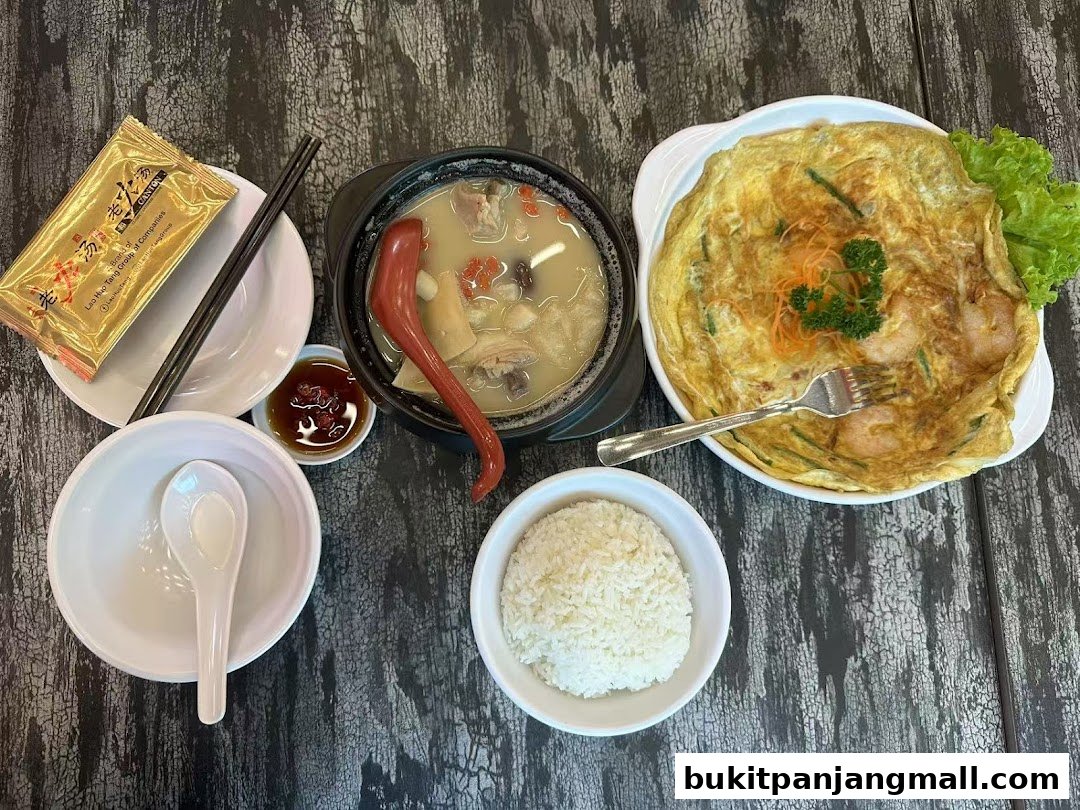 A delicious meal featuring a hearty soup, omelette with shrimp, and a bowl of rice.