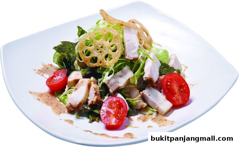 A delicious chicken salad with tomatoes and lotus root on a white plate.