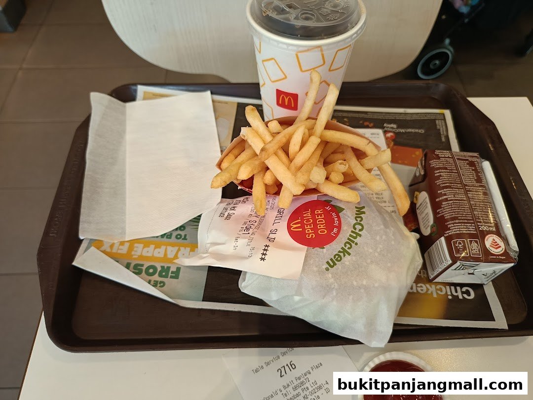 A tray of McDonald's food including a McCrispy chicken burger, fries, a drink, and a chocolate milk.