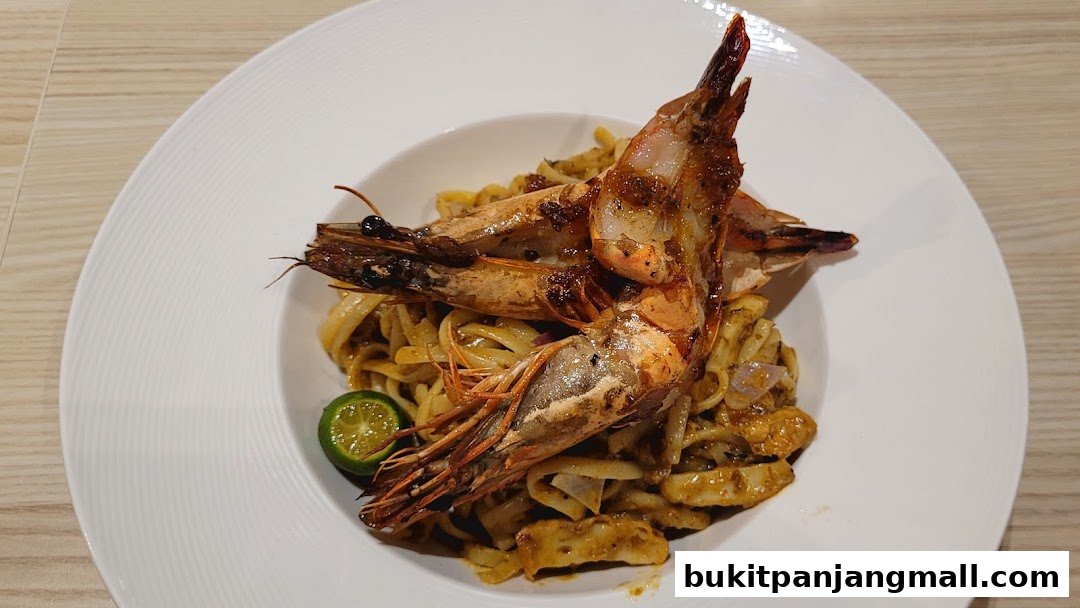A plate of pasta with large grilled prawns and a lime wedge.