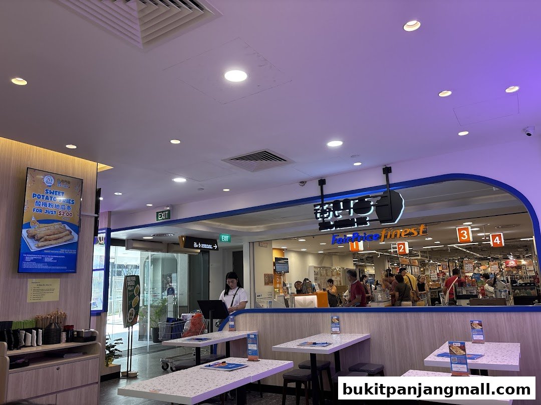 Interior view of a Taiwanese food stall with tables and a view into a FairPrice Finest supermarket.