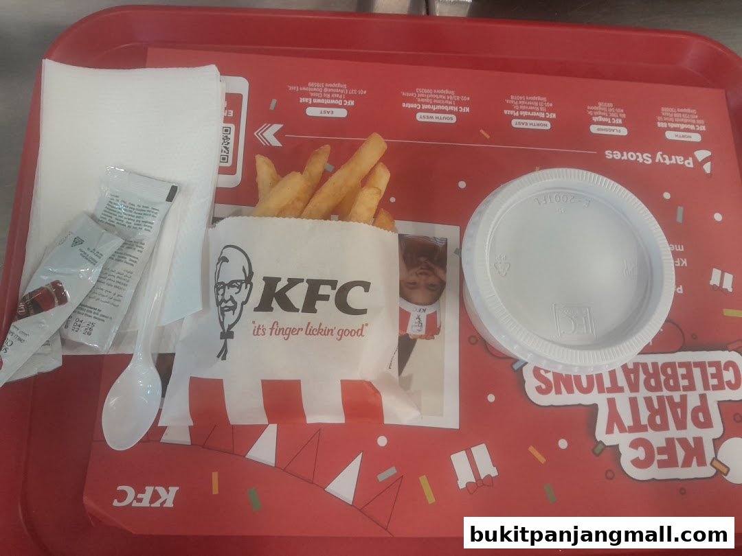 A tray of KFC fries, a sauce cup, and napkins on a red KFC branded tray.