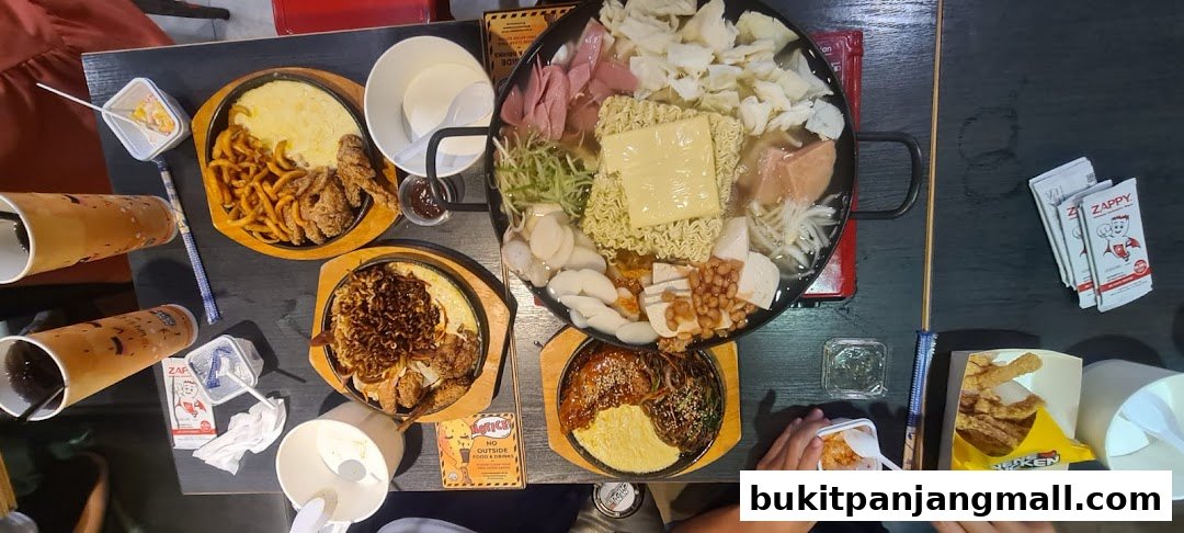 A table filled with various Korean dishes, including fried chicken, hot pot, and drinks.