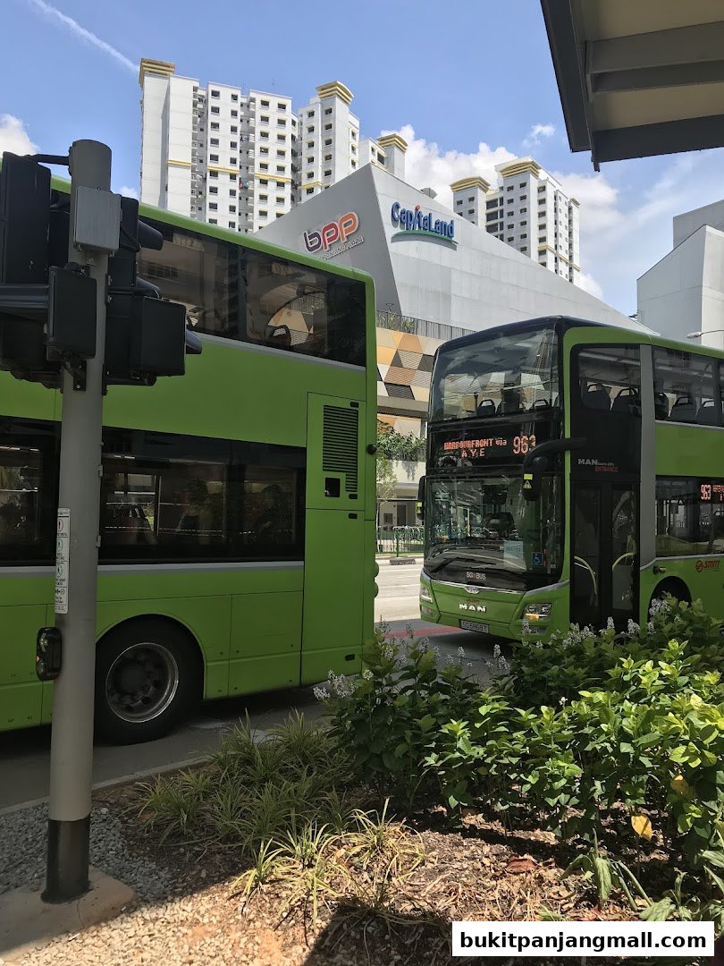 Two green buses are parked in front of a building with 'bpp' and 'Capitaland' logos.