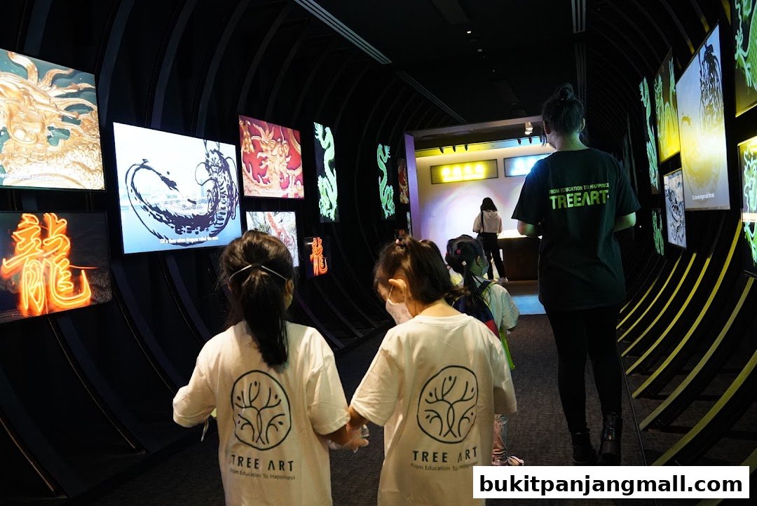 Children and an adult observe dragon-themed digital art displays in a modern exhibition space.