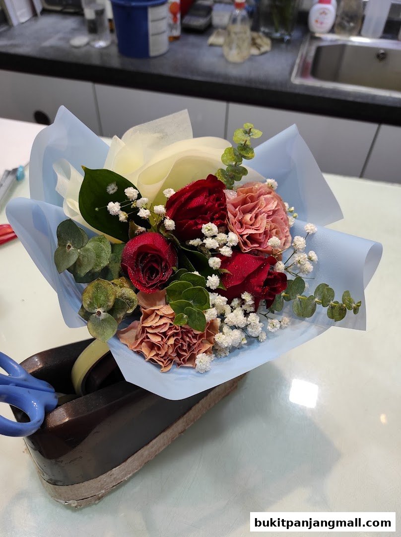 A beautiful bouquet of red roses and carnations with baby's breath and eucalyptus.
