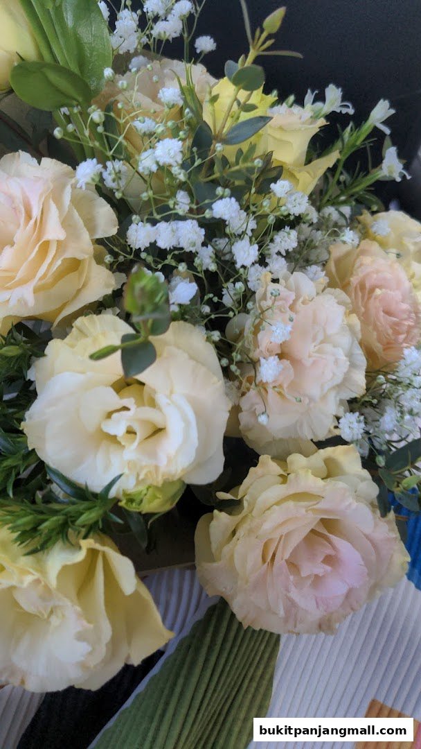 A close-up of a beautiful bouquet of light yellow and pink roses with baby's breath.