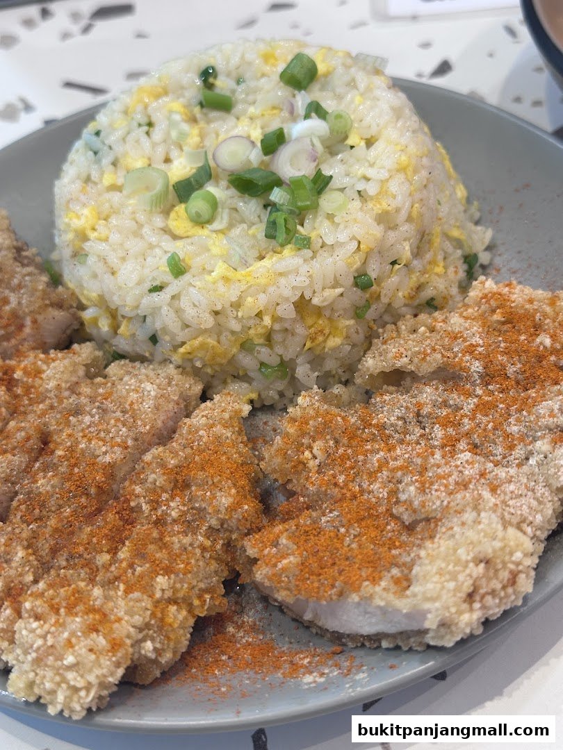 A close-up of a Taiwanese meal featuring fried chicken cutlets and egg fried rice.