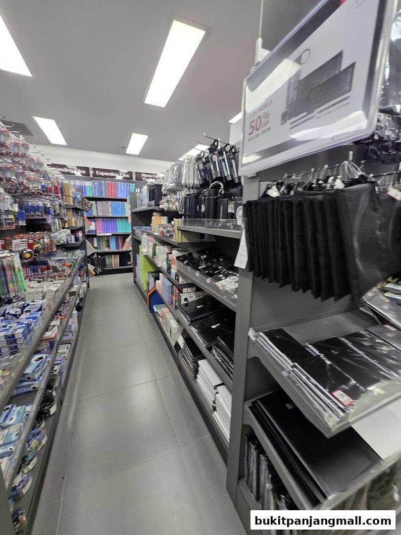 A wide aisle in a POPULAR Bookstore, showcasing shelves filled with stationery and office supplies.