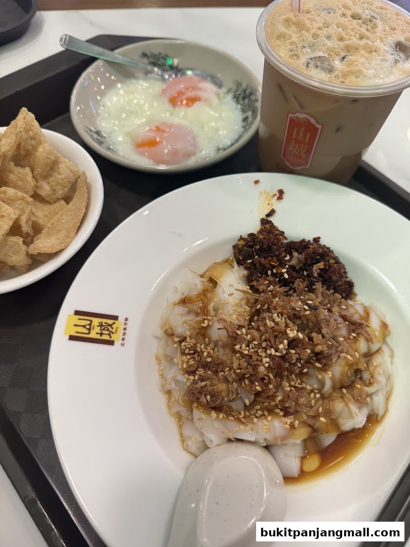 A close-up of Ipoh delicacies including chee cheong fun, soft-boiled eggs, and a drink.