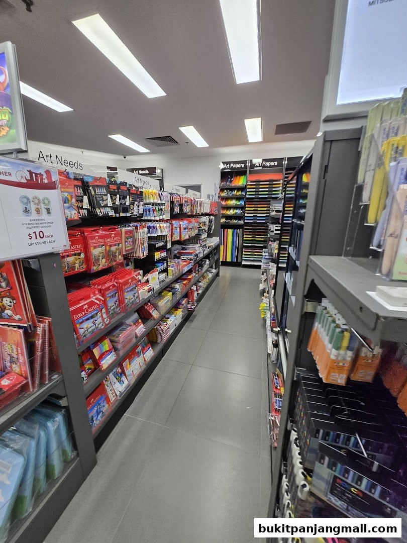 A wide aisle in a POPULAR Bookstore, showcasing art supplies and stationery on shelves.