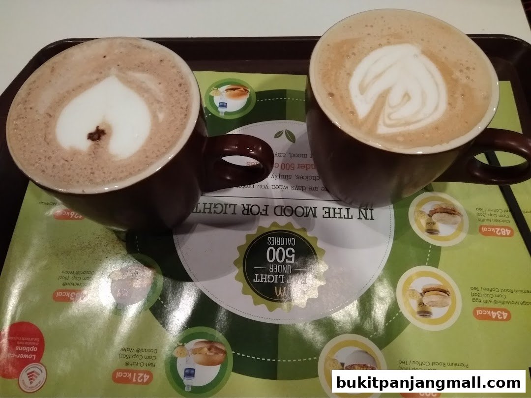 Two cups of coffee with latte art on a tray with a menu featuring calorie information.