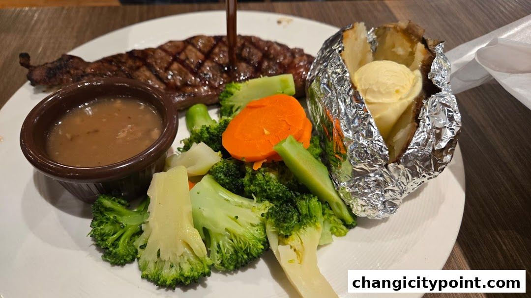 A grilled steak served with steamed vegetables, gravy, and a foil-wrapped baked potato with butter.