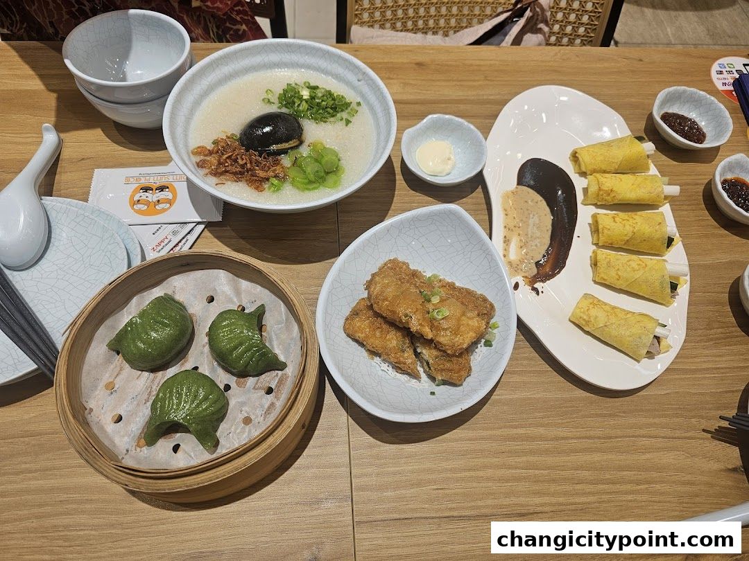 A table laden with various dim sum dishes, including dumplings, congee, and spring rolls.