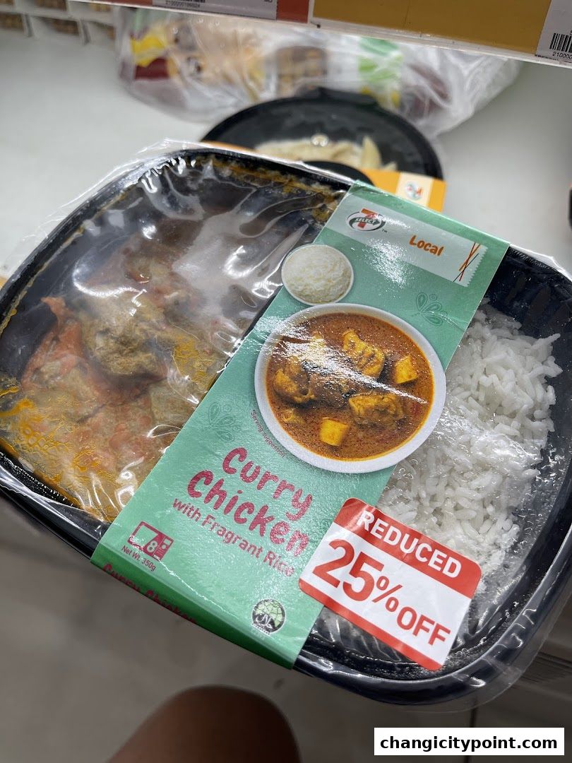 A pre-packaged meal of Curry Chicken with Fragrant Rice from 7-Eleven with a 25% off sticker.