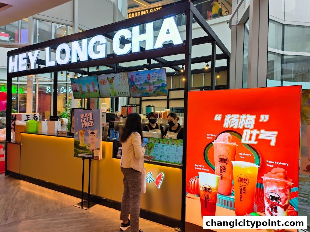 A Hey Long Cha bubble tea stall with staff serving customers and promotional displays.