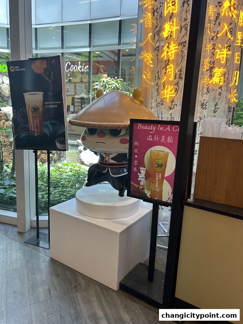 A mascot and promotional posters for Hey Long Cha bubble tea shop.