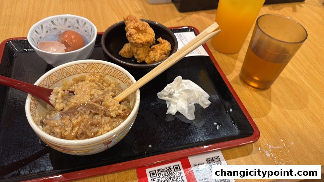 A Sukiya meal set with gyudon, fried chicken, and drinks on a tray.