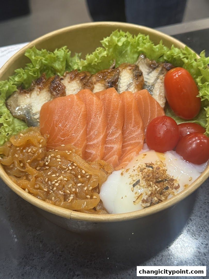 A bowl of salmon and eel donburi with cherry tomatoes and lettuce.