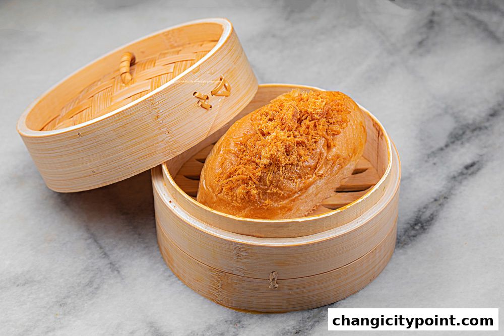 A fluffy bun topped with shredded meat in a bamboo steamer.