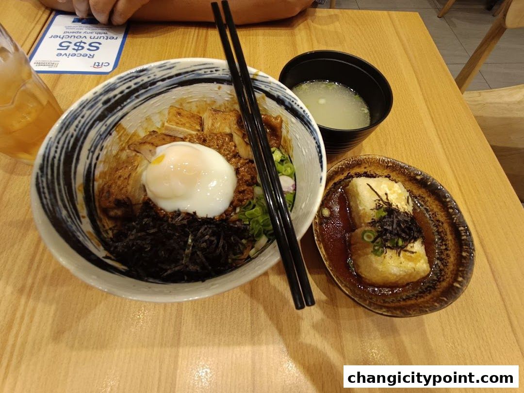 A delicious bowl of Japanese rice with toppings, soup, and fried tofu.