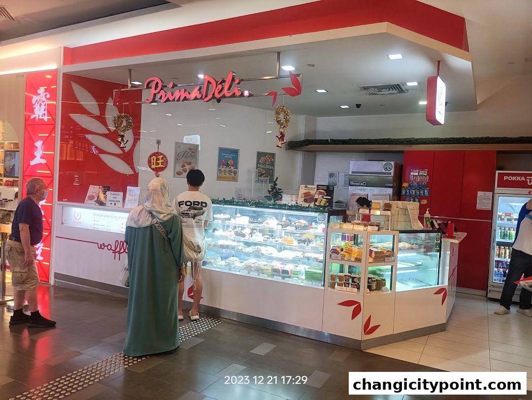 PrimaDéli bakery shop with display cases full of cakes and pastries.