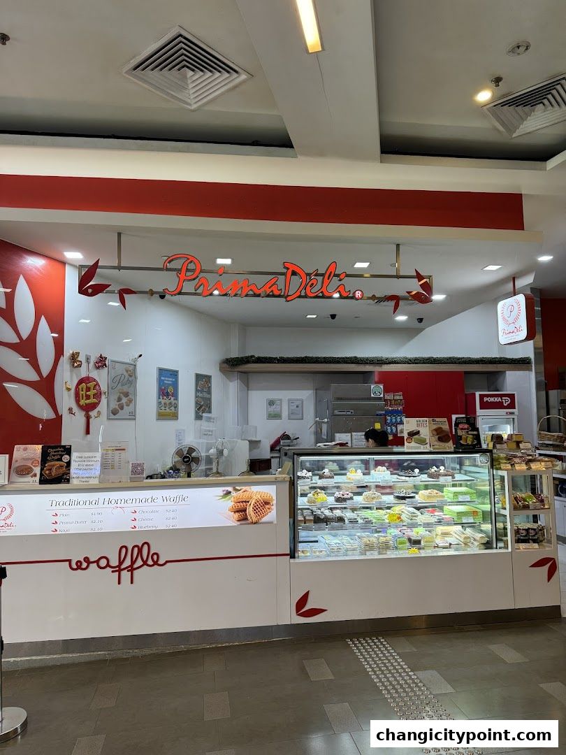 PrimaDéli bakery shop with a display of cakes and waffles.
