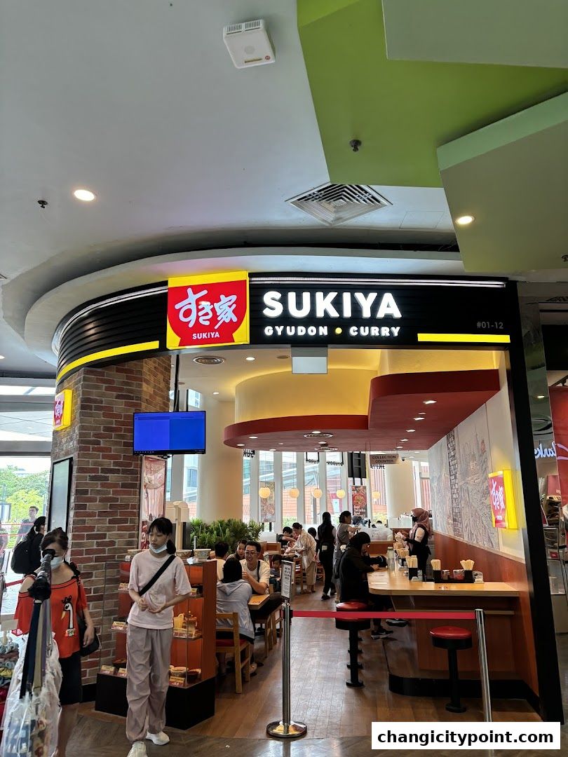 The entrance of Sukiya Gyudon Curry restaurant with customers dining inside.