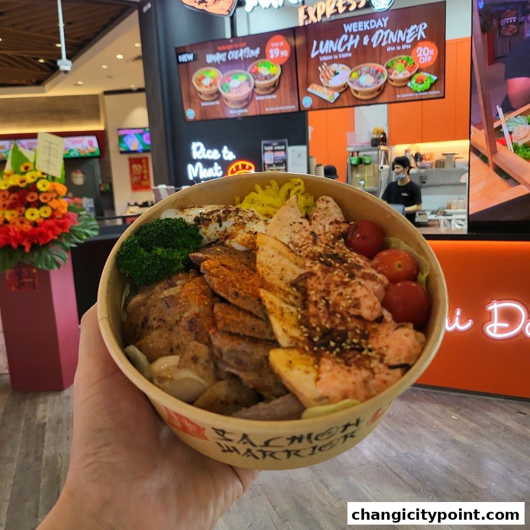 A hand holds a bowl of salmon and chicken rice with vegetables in front of a restaurant.