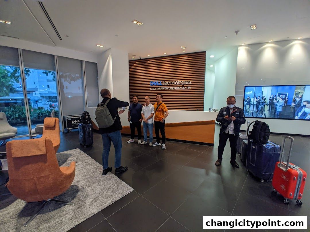 People gather in the modern lobby of Dell Technologies, with luggage present.