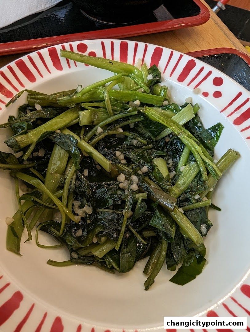 A close-up of a plate of stir-fried water spinach with garlic.