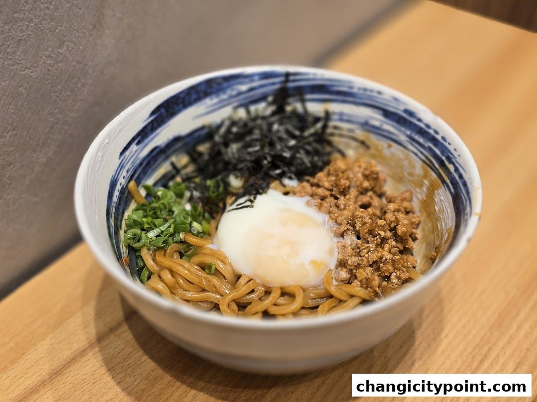 A delicious bowl of noodles with minced meat, egg, and seaweed.