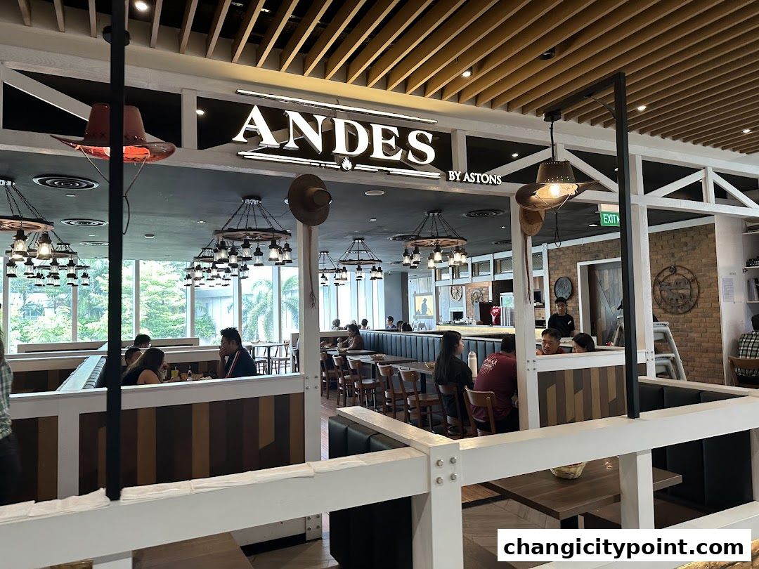 Interior view of ANDES by ASTONS restaurant with diners and rustic decor.