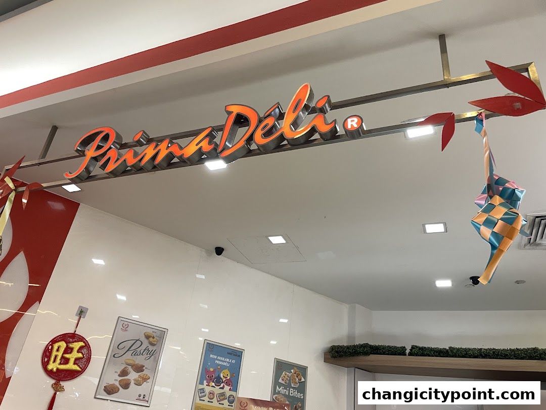 The PrimaDéli shop sign with festive decorations hanging.