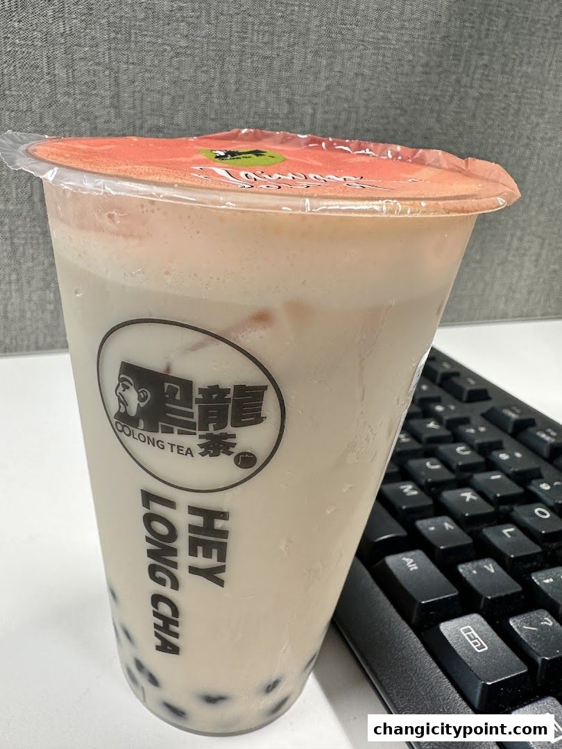 A cup of bubble tea from Hey Long Cha with tapioca pearls and a keyboard.