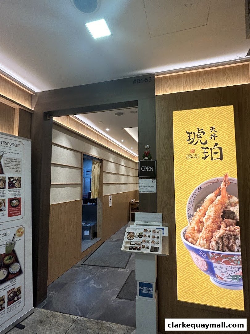 The entrance to Tendon Kohaku, a Japanese restaurant, with a large illuminated sign and a menu display.