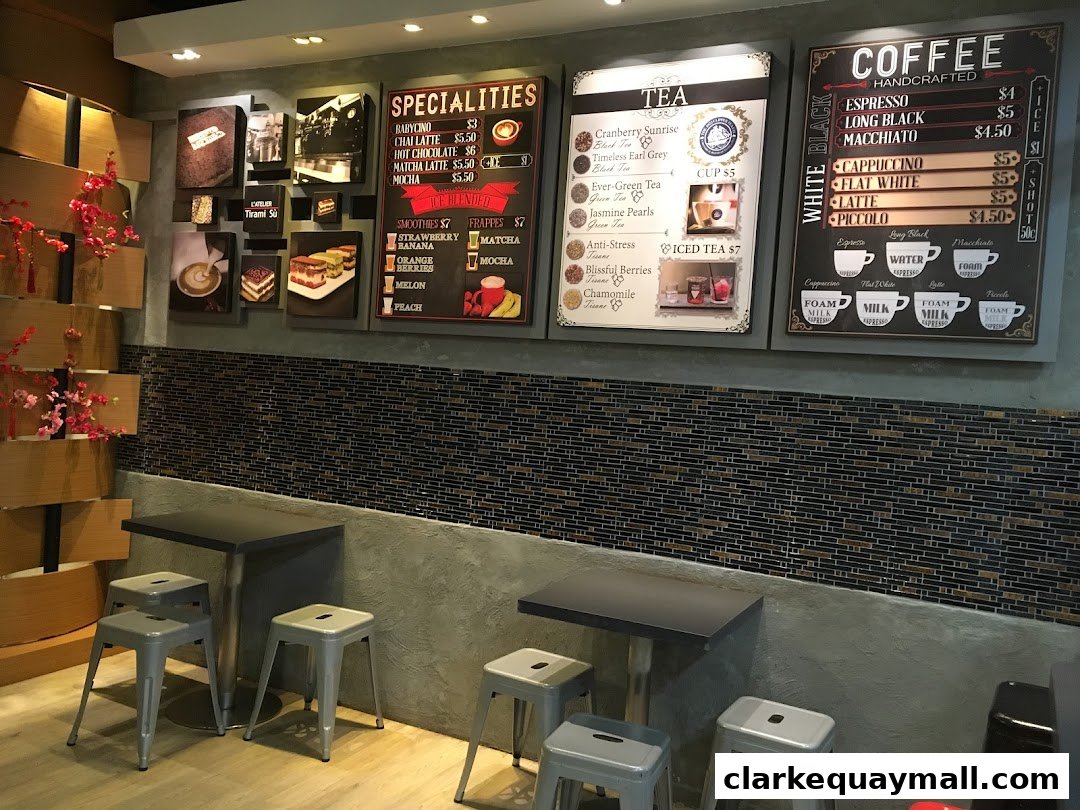 A cafe interior with menus displaying coffee, tea, and specialties, along with seating.