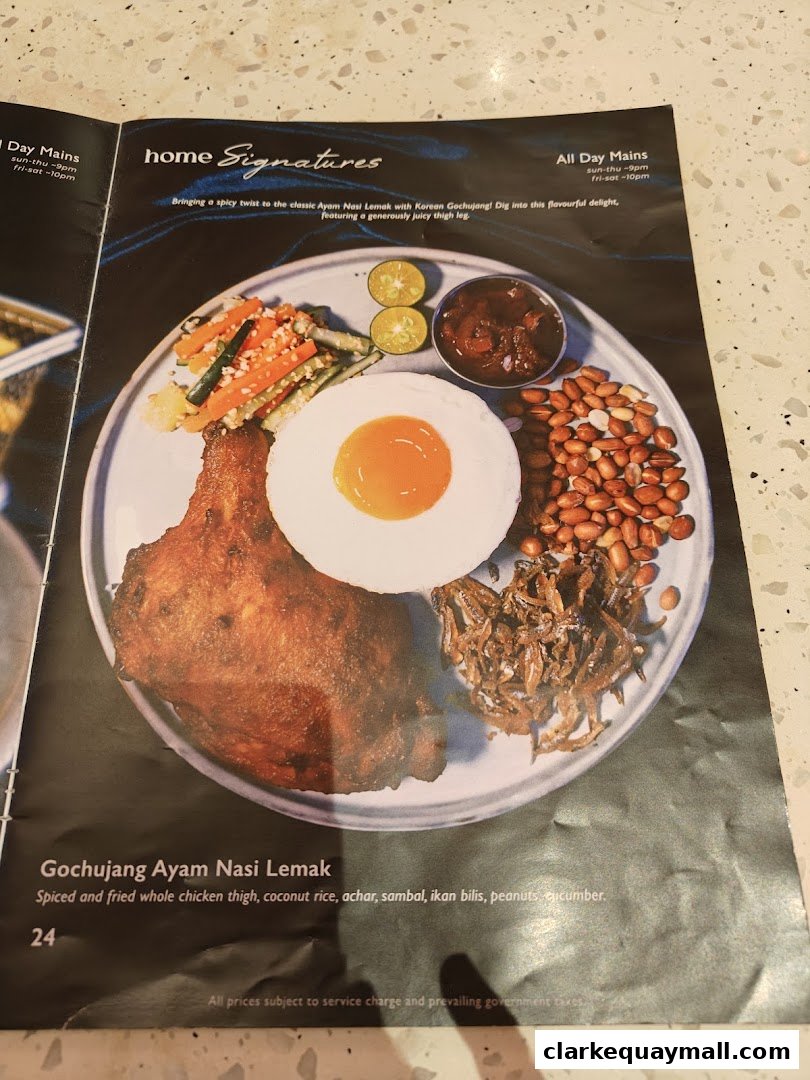 A menu item featuring Gochujang Ayam Nasi Lemak with fried chicken thigh and various accompaniments.