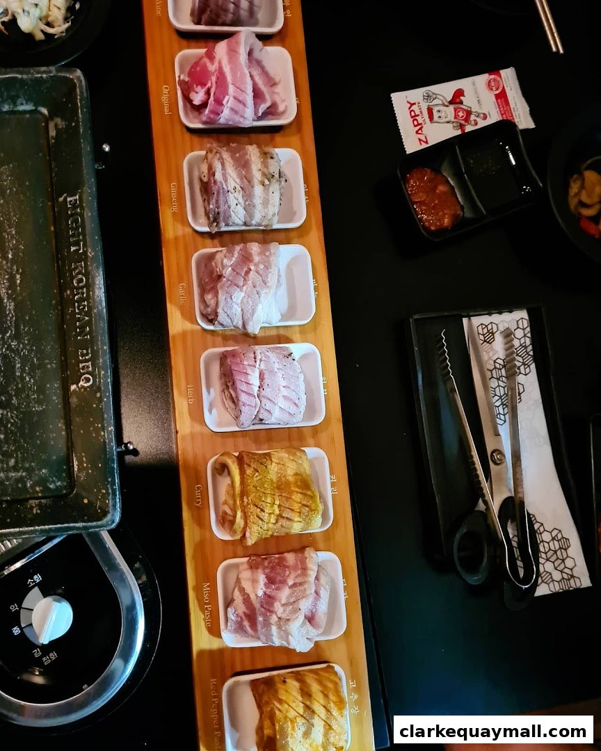 A selection of marinated meats for Korean BBQ, presented on a wooden board with labels.