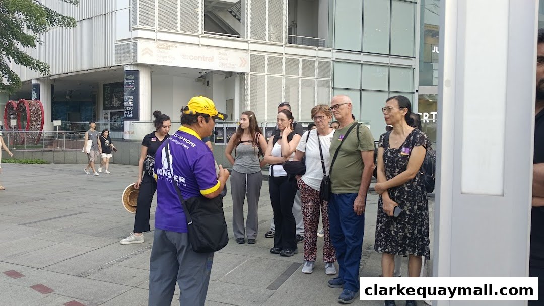 A tour guide speaks to a group of tourists outside a shopping mall.